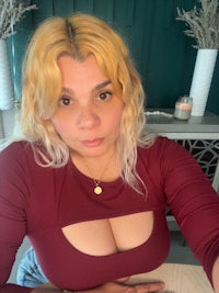 a woman in a maroon top posing for a selfie